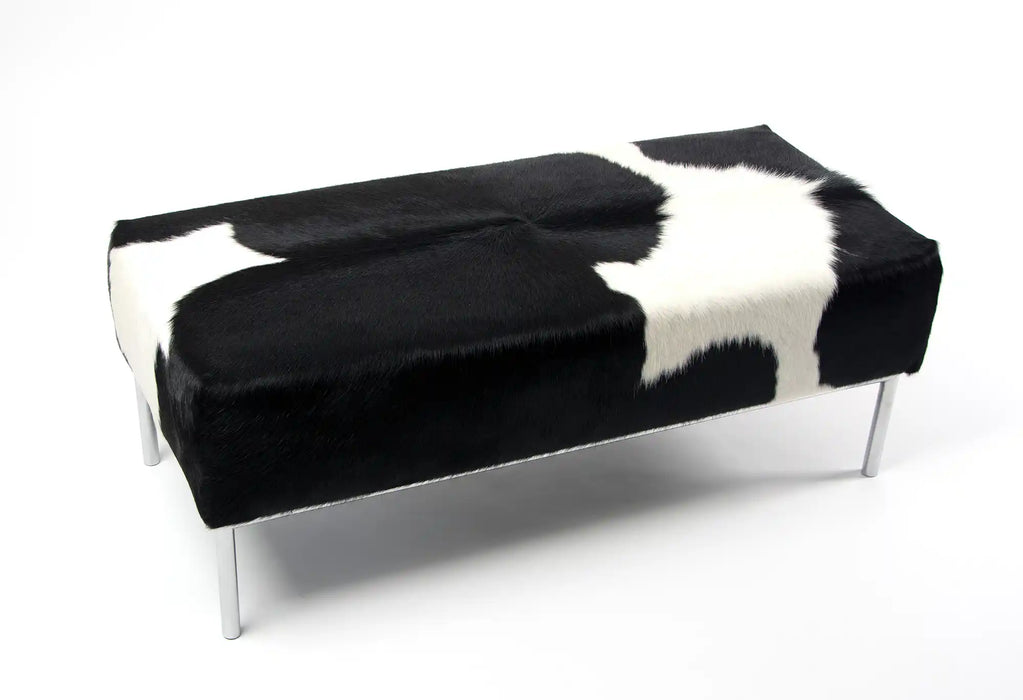 Black & white cowhide ottoman with metal feature rail base