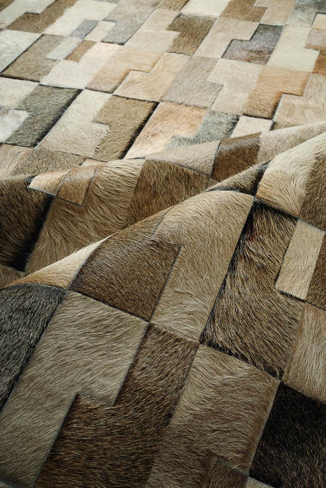 Beige cowhide patchwork rug close up