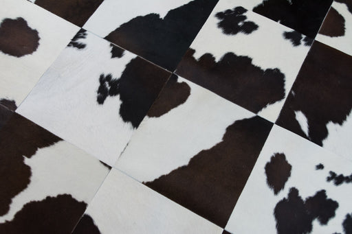 Dark brown and white cowhide patchwork rug close up