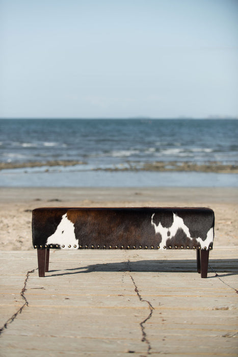 Long bench ottoman in cowhide with studs